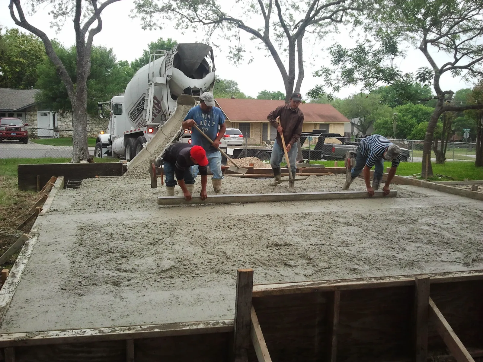 Crew pouring and finishing a residential concrete driveway