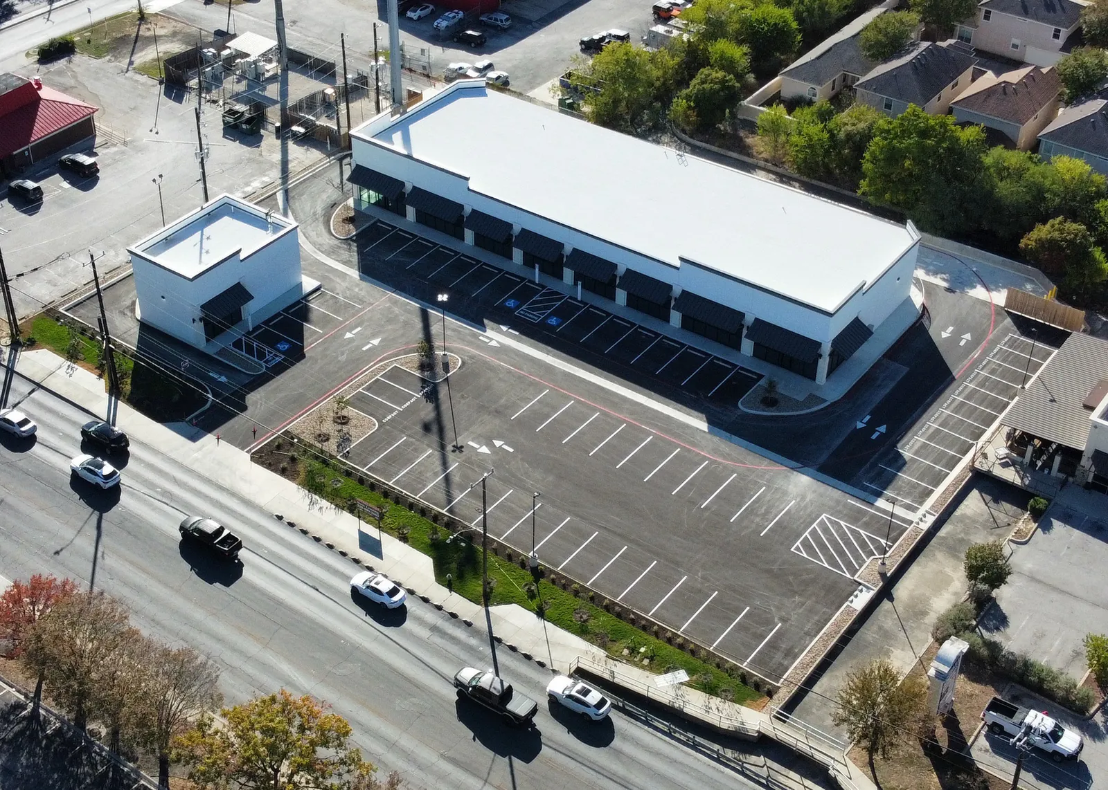 Aerial view of a completed retail center with new concrete sitework and parking