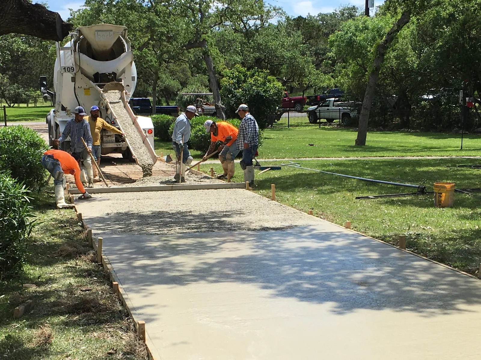 Crew pouring a new neighborhood sidewalk from a mixer truck