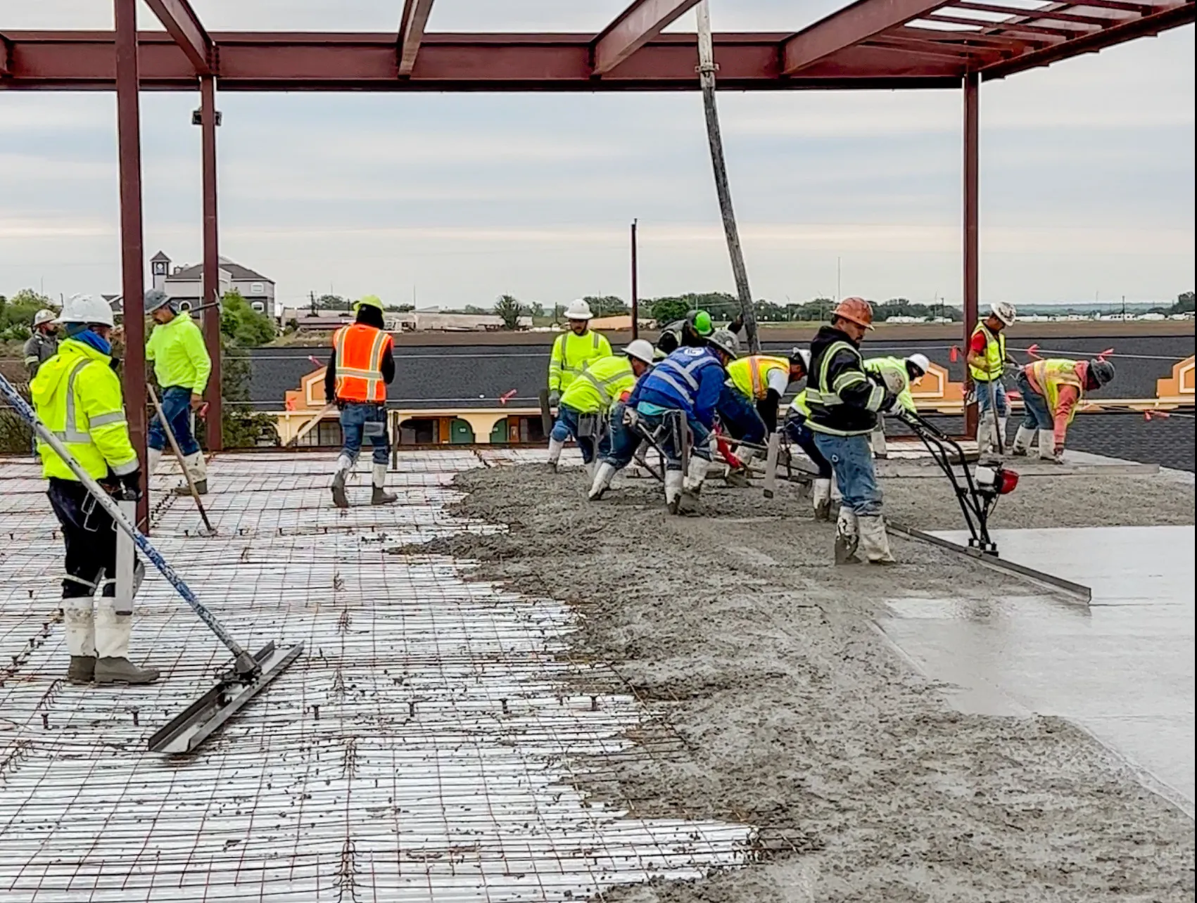 Crew placing a slab inside a steel building frame