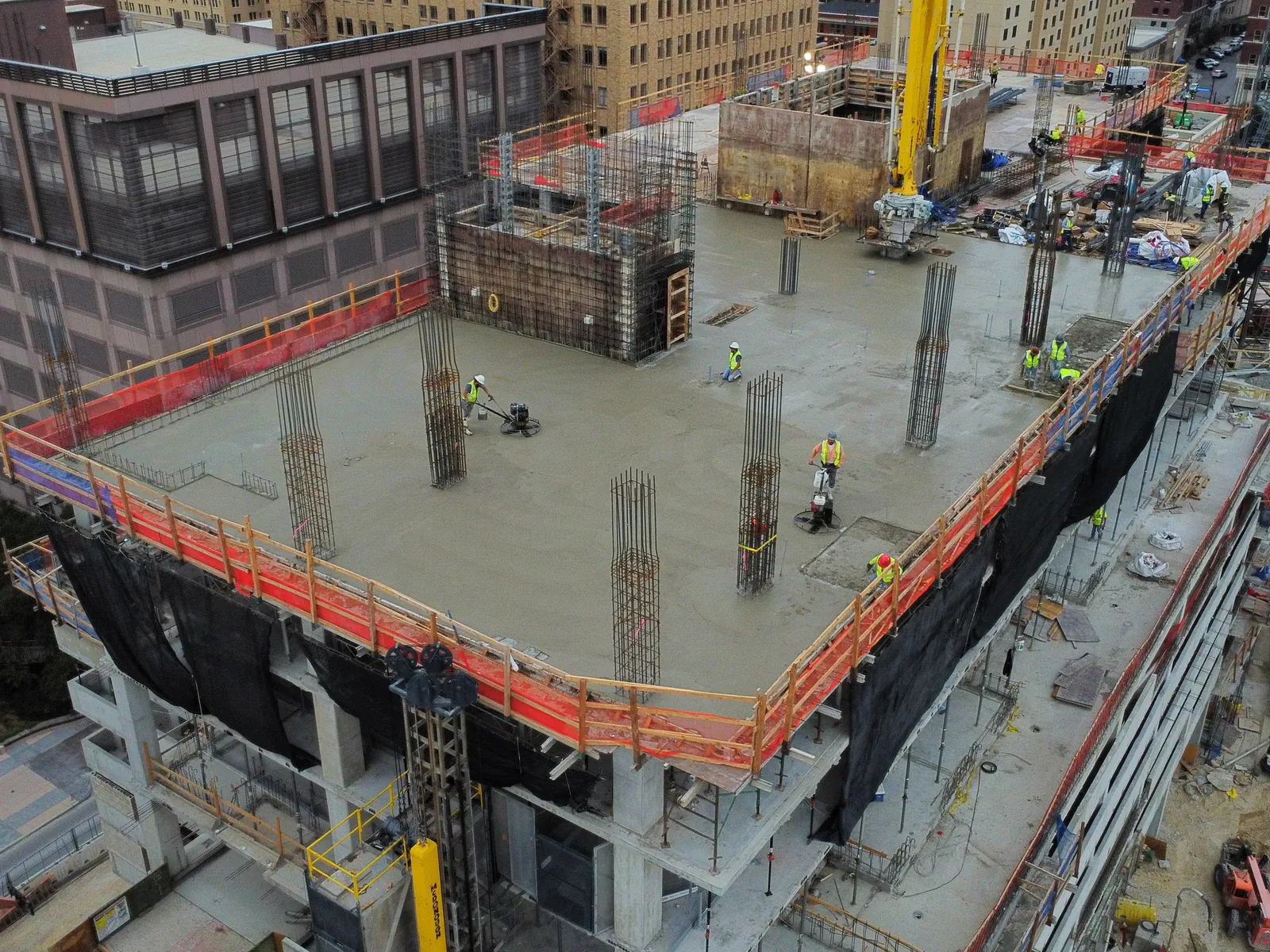 Aerial view of a multi-story structural concrete deck pour with crane